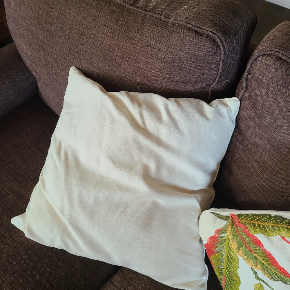 2 pillows with embroidered flowers and hummingbirds